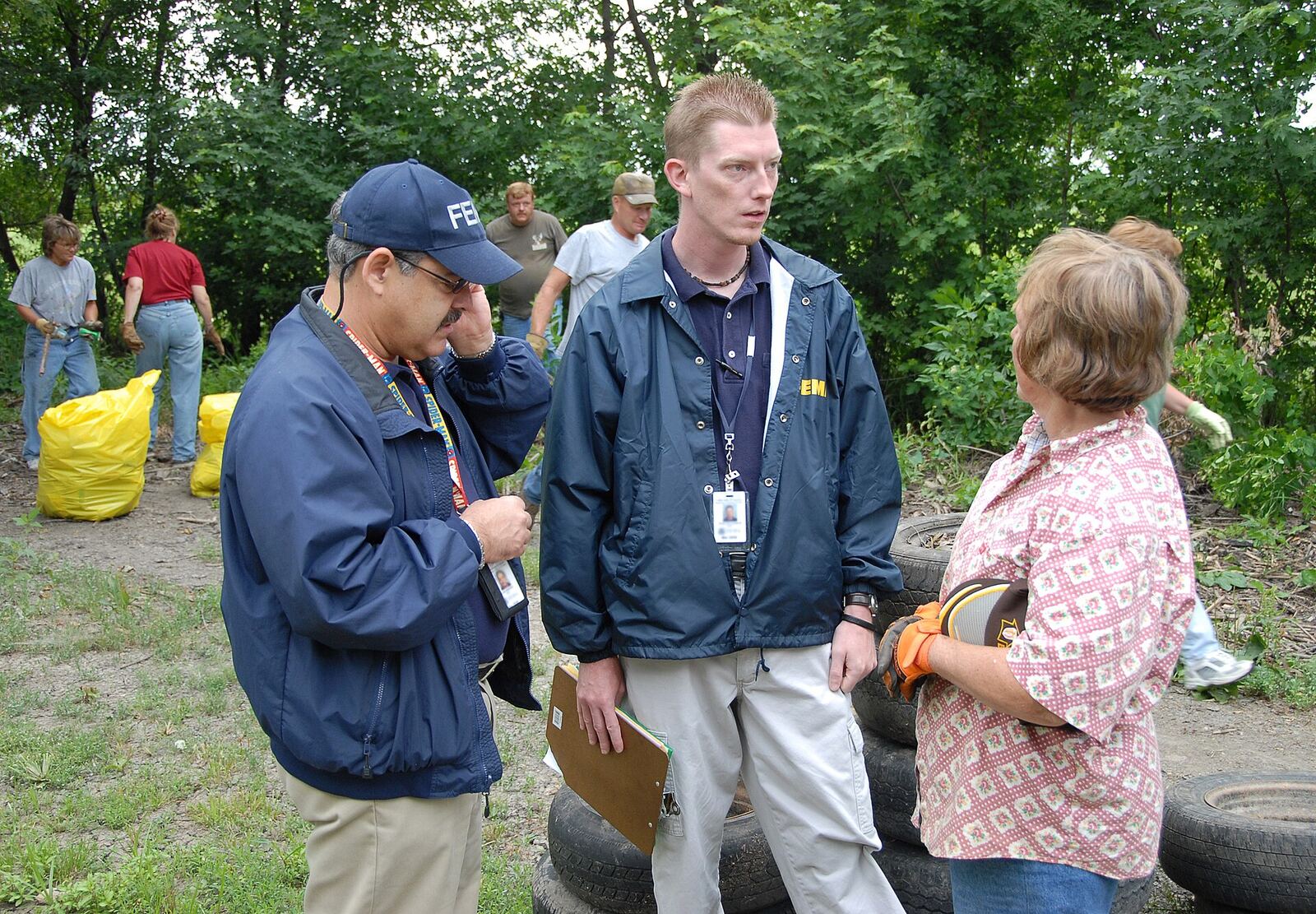 Rosendale, MO, 6-30-07 -- FEMA Community Relations Specialists Luis Miranda and Chad McCormick talk with Dawn Blair who organized a group of clean up volunteers. Community Relations Specialists are in the flood damaged area to let people know about Disaster Recovery Centers opening up and registering for FEMA aid that may be available to them under the Individual Assistance Program. Marvin Nauman/FEMA photo