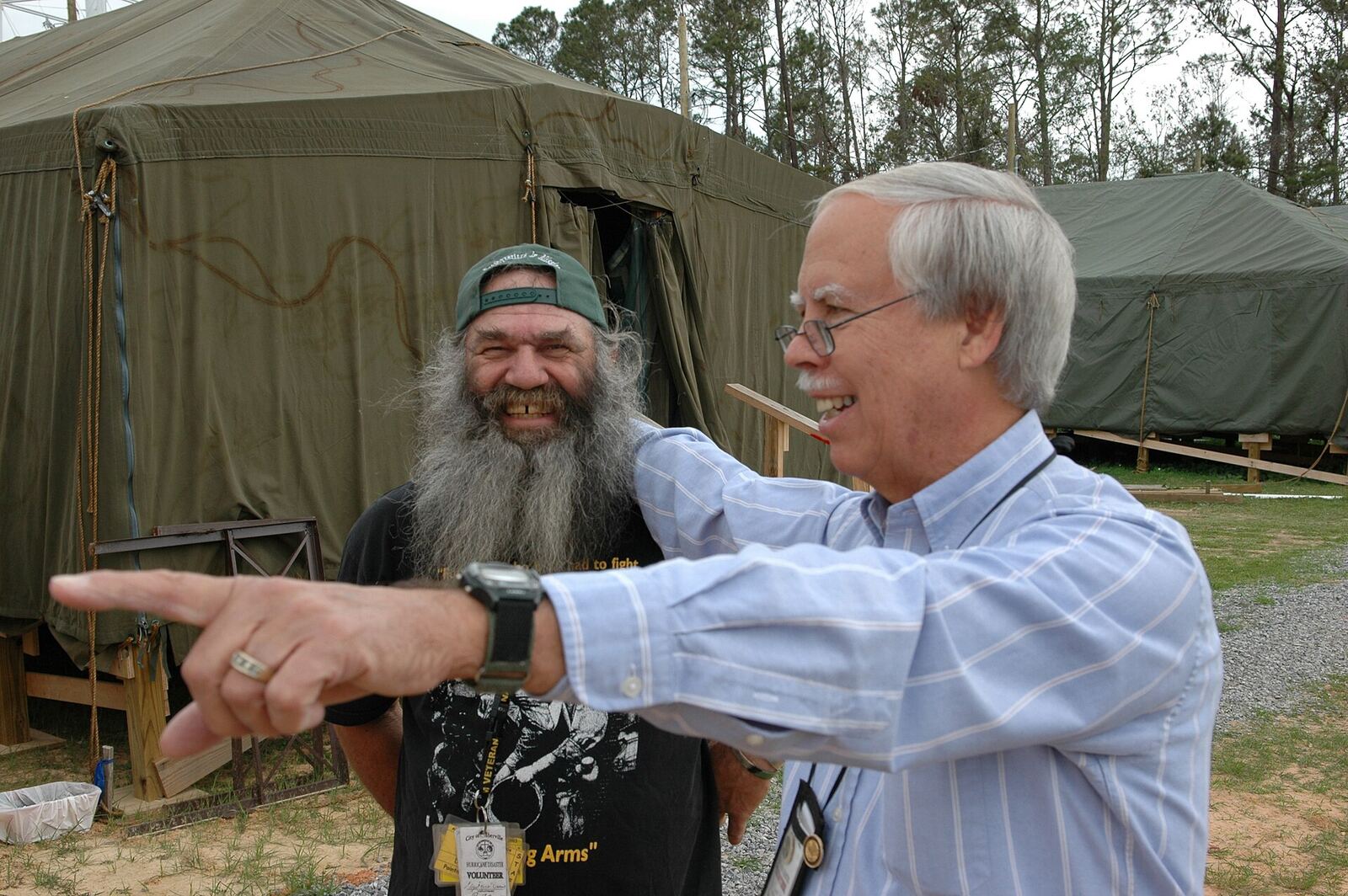 D'Iberville, Miss., March 16, 2006 -- Ed Cake, Ph.D. (right), volunteer Vice-President of the D'Iberville Volunteers Foundation points the cook, Dick Darnell, toward the mess tent. The foundation was created to ensure a fast, strong recovery for the community. Mark Wolfe/FEMA